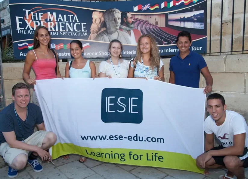 Apprendre l'anglais à Malte : étudiants heureux arborant une banderole de l'école ESE Malta
